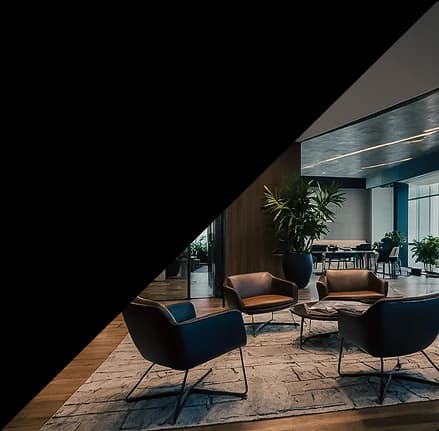 Lounge corporativo com poltronas e plantas decorativas.